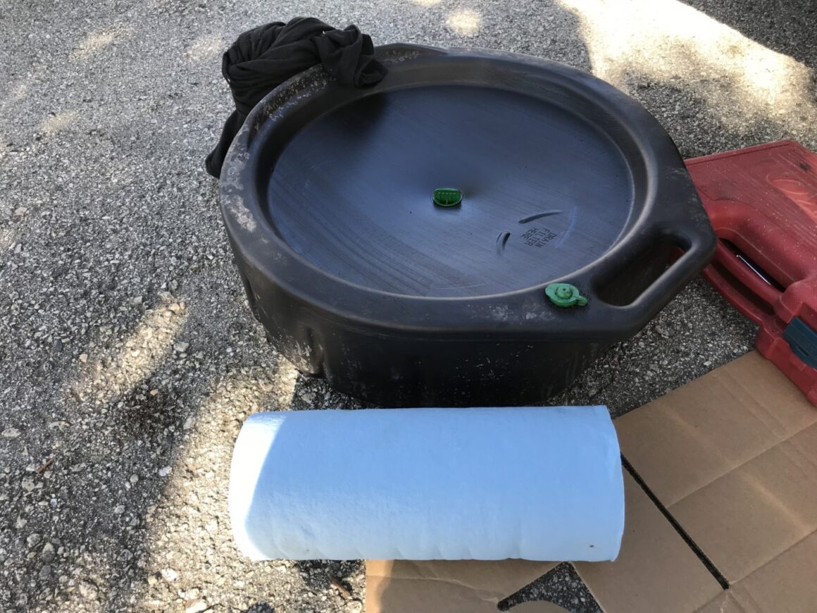 oil drain pan and blue shop towels