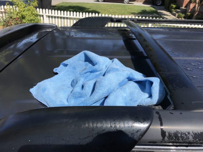using a microfiber towel to dry exterior of a car